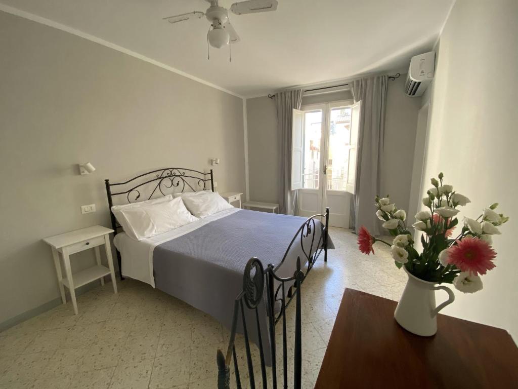 een slaapkamer met een bed en een tafel met een vaas met bloemen bij Dimora Bro in Conversano