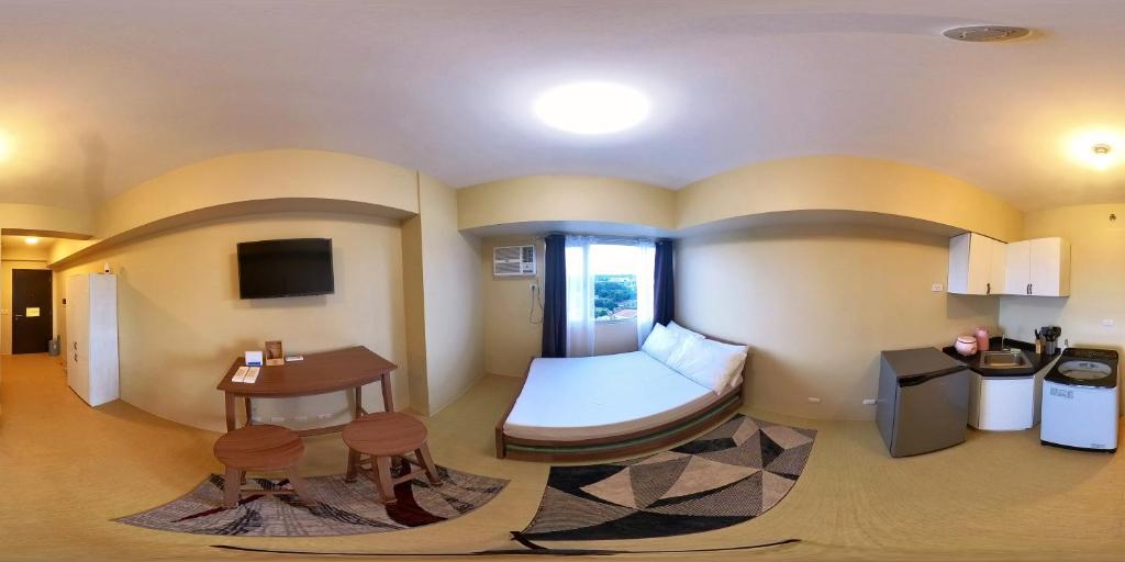 Camera con letto, scrivania e tavolo. di Nazaire Suite Avida Towers Aspira a Cagayan de Oro