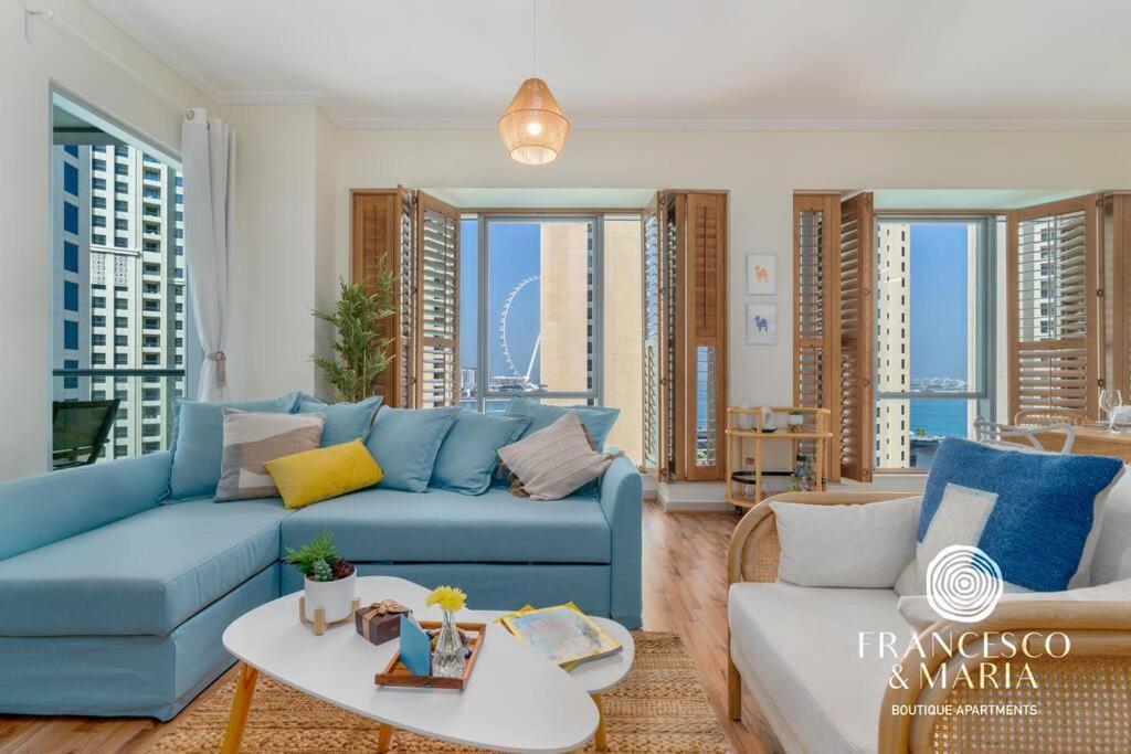 a living room with a blue couch and a table at Boutique Apartment Sea Views - Dubai Marina in Dubai