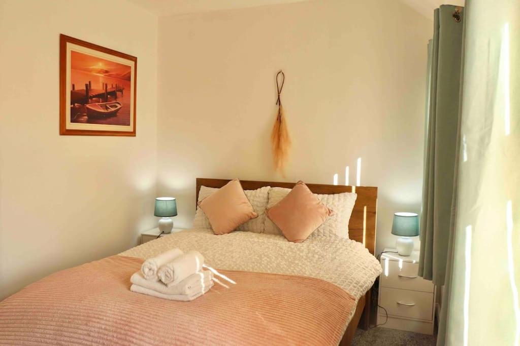 a bedroom with a bed with two towels on it at Stunning Guest House FREE WiFi &Parking in Hunslet