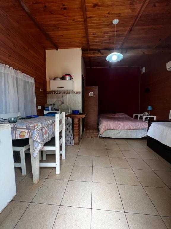 um quarto com uma mesa e uma cama em Cabañas La Delfina em Puerto Iguazú
