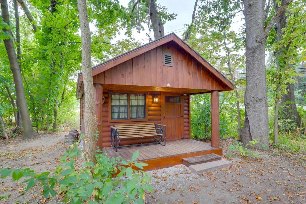 a cabin in the woods with a bench on a deck at Peaceful South Bend Vacation Rental with Fire Pit in South Bend