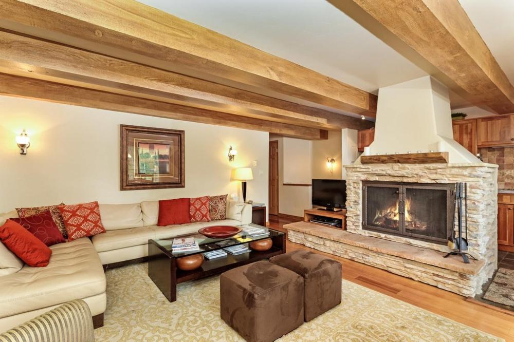 een woonkamer met een bank en een open haard bij Chateau Roaring Fork Unit 22, Spacious Condo with Beautiful River Views, 4 Blocks to Town in Aspen