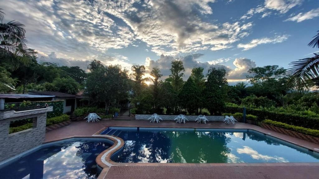 una piscina en un patio con un cielo nublado en Centro Vacacional Campo Alegre, en Guamal