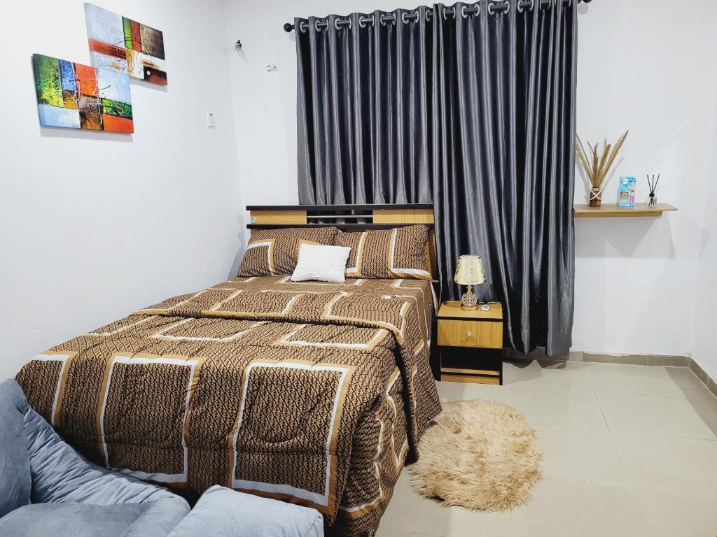 um quarto com uma cama e uma janela com cortinas em Dezra Homes em Lagos
