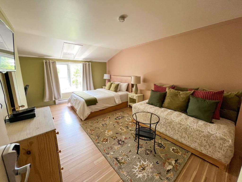1 dormitorio con 1 cama y 1 sofá en una habitación en Auberge la Rosepierre bistro Henri, en Grandes-Bergeronnes
