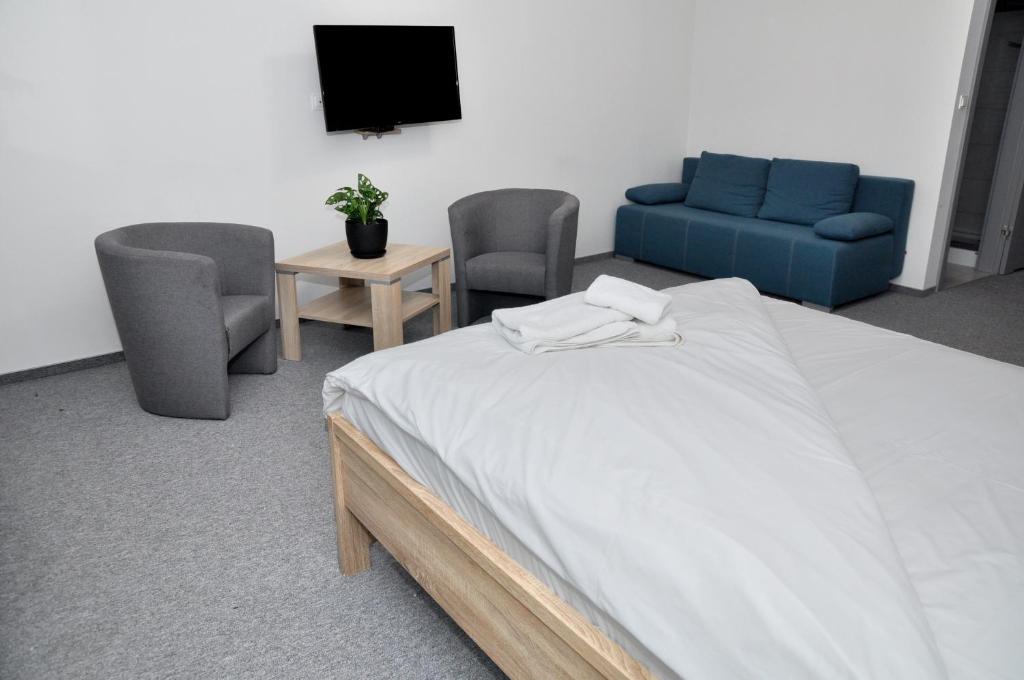 una camera con un letto, due sedie e una TV di Pokoje, Apartamenty, Restauracja Marcus a Oborniki