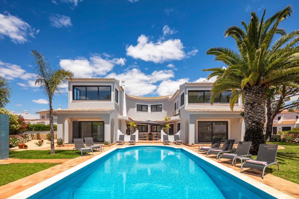 une grande villa avec une piscine et des palmiers dans l'établissement Casa Diamante, à Carvoeiro