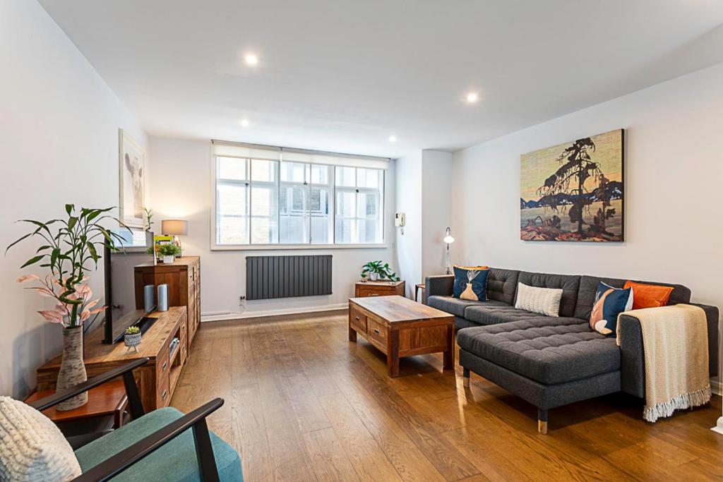 a living room with a couch and a tv at Blackfriars Printhouse Retreat in London