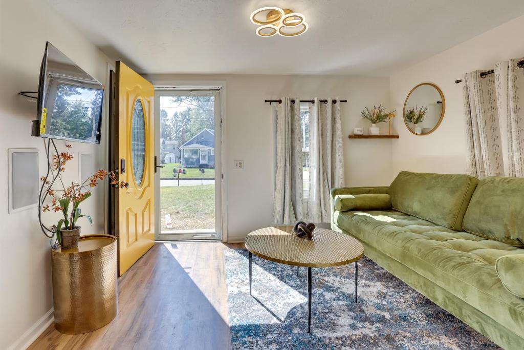 uma sala de estar com um sofá verde e uma mesa em Modern Northfield Cottage with Yard! em Northfield