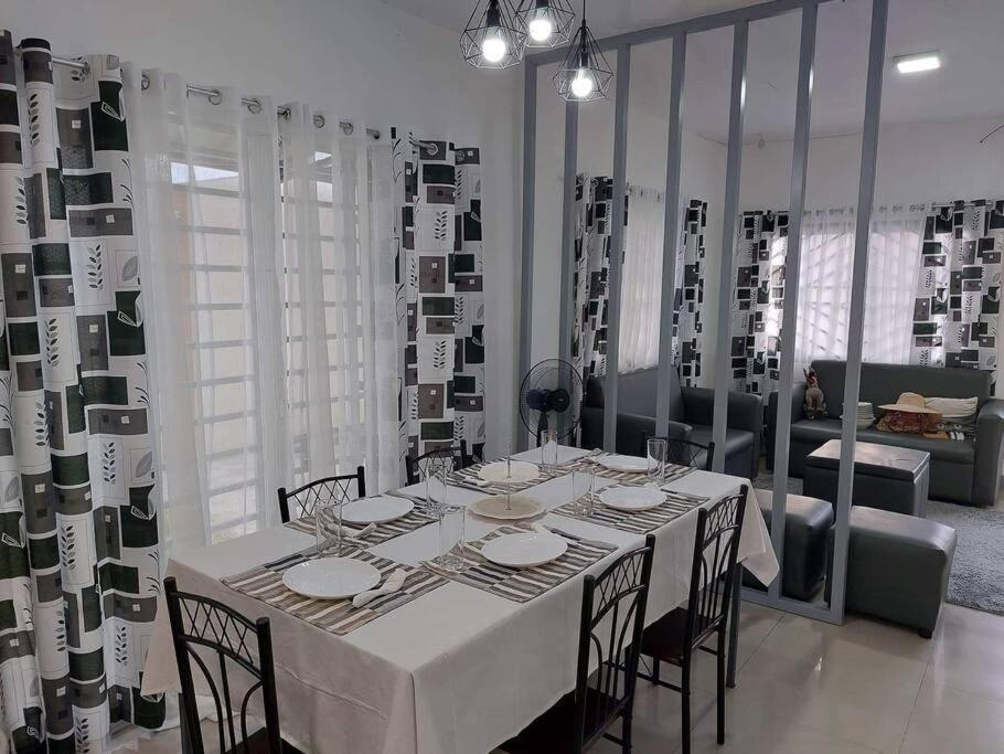 ein Esszimmer mit einem weißen Tisch und Stühlen in der Unterkunft FOMAG House GenSan 2BR in General Santos