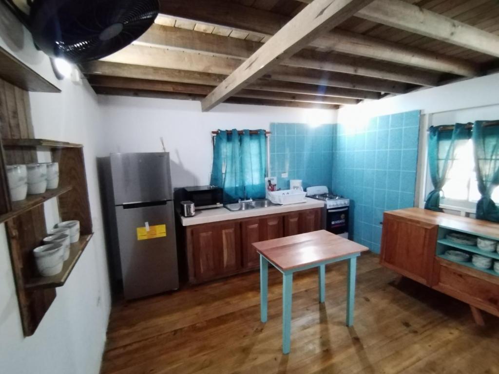 a small kitchen with a table and a refrigerator at Hotel Tierra Verde Bed and Breakfast in Bocas del Toro