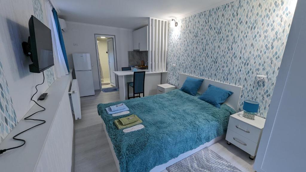 Dormitorio pequeño con cama azul y cocina en White Orchid en Mtskheta