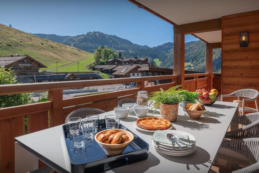 a table with food on top of a balcony at Le Grand Bossonnet - OVO Network in La Clusaz