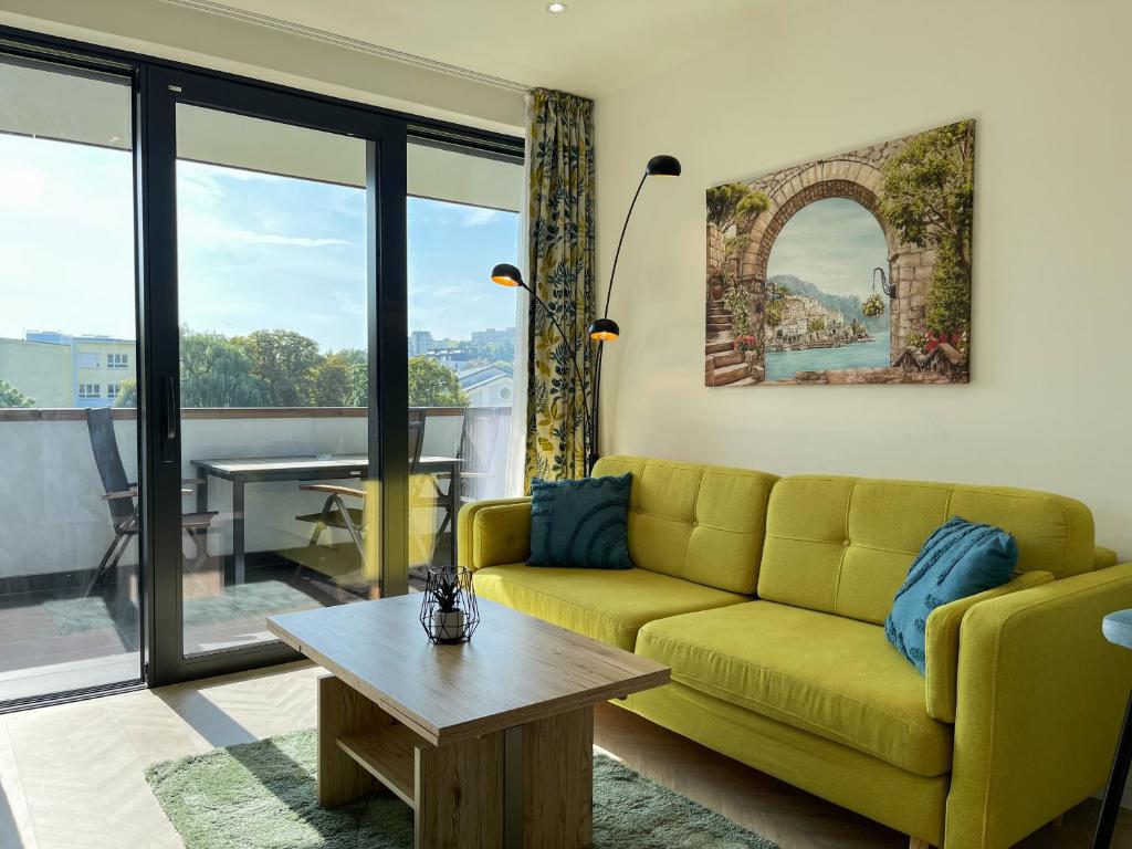 a living room with a yellow couch and a table at Luxury City Retreat with Terrace in Košice