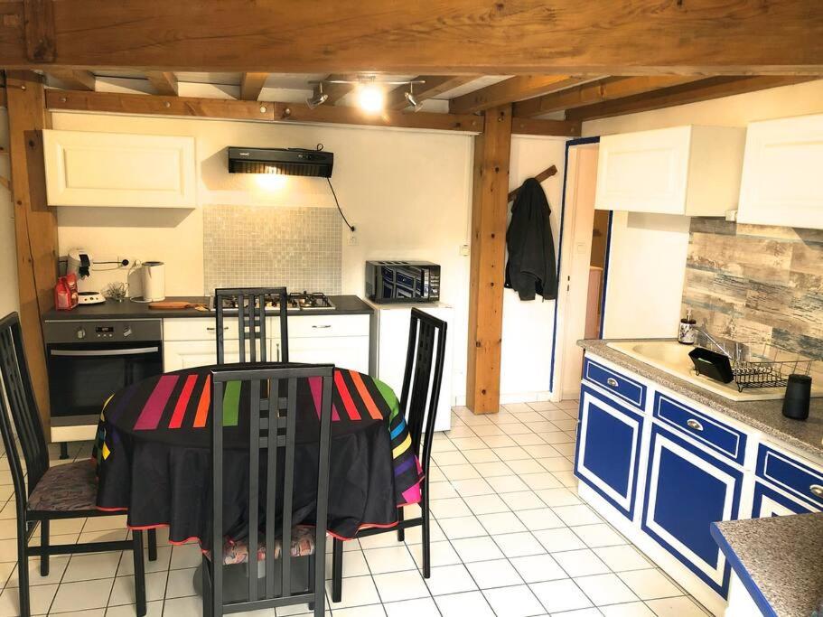 eine Küche mit einem Tisch und Stühlen im Zimmer in der Unterkunft Appartement RDC dans jolie parc Arboré in Beure