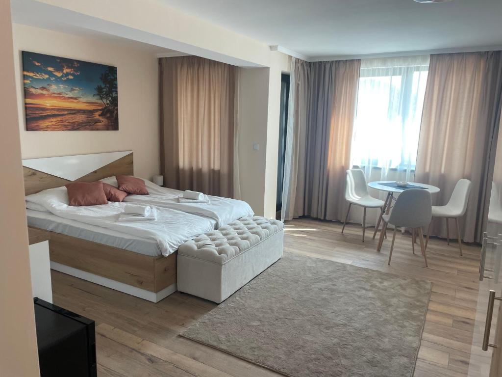 a bedroom with a bed and a table and chairs at Teddy Apartment in Veliko Tŭrnovo
