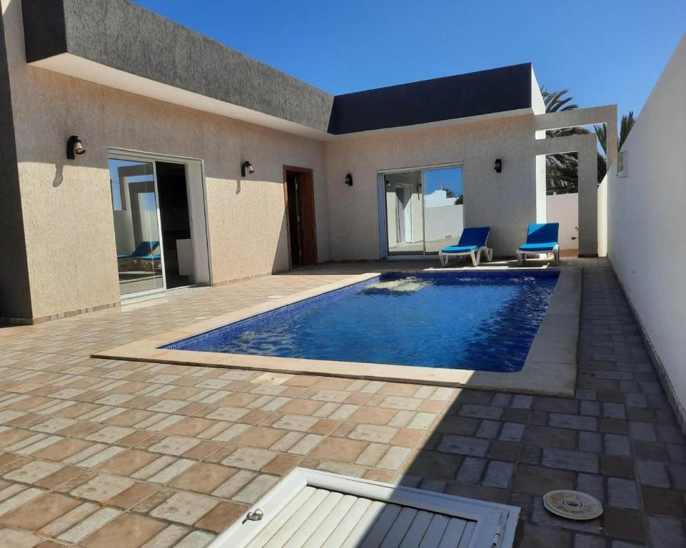 a swimming pool in front of a house at Dar Adam in Taguermess