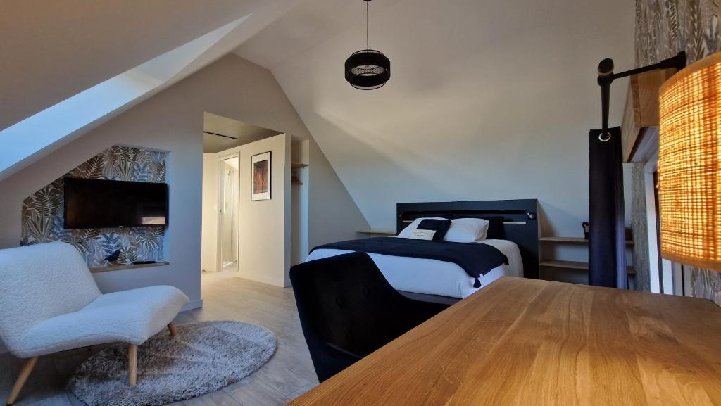 a bedroom with two beds and a table and a chair at Meublé 5* Au gré des saisons in La Baconnière