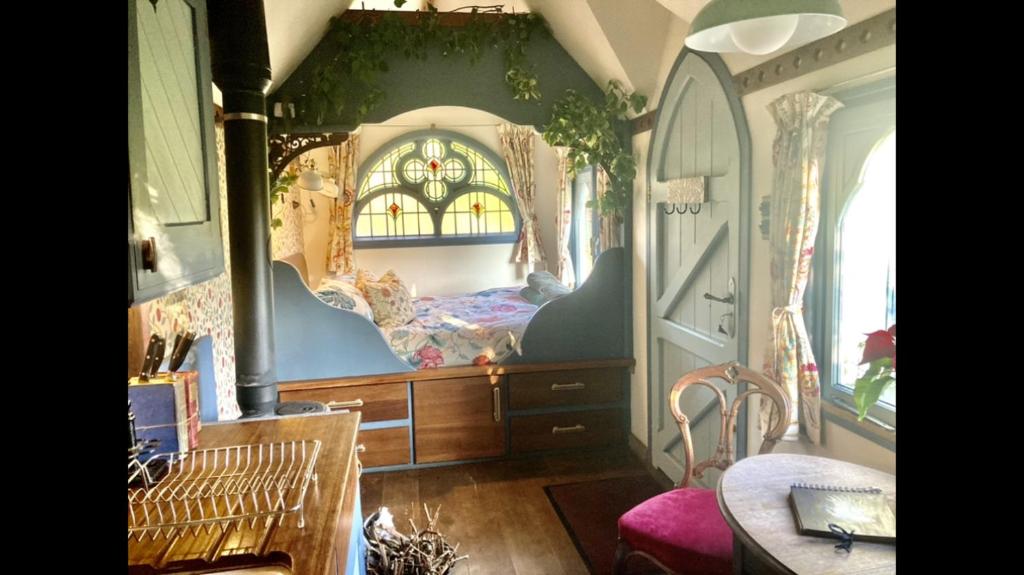um quarto com uma cama num quarto com uma janela em Magical Tabernacle in a Beautiful Setting with Hot Tub em Bude