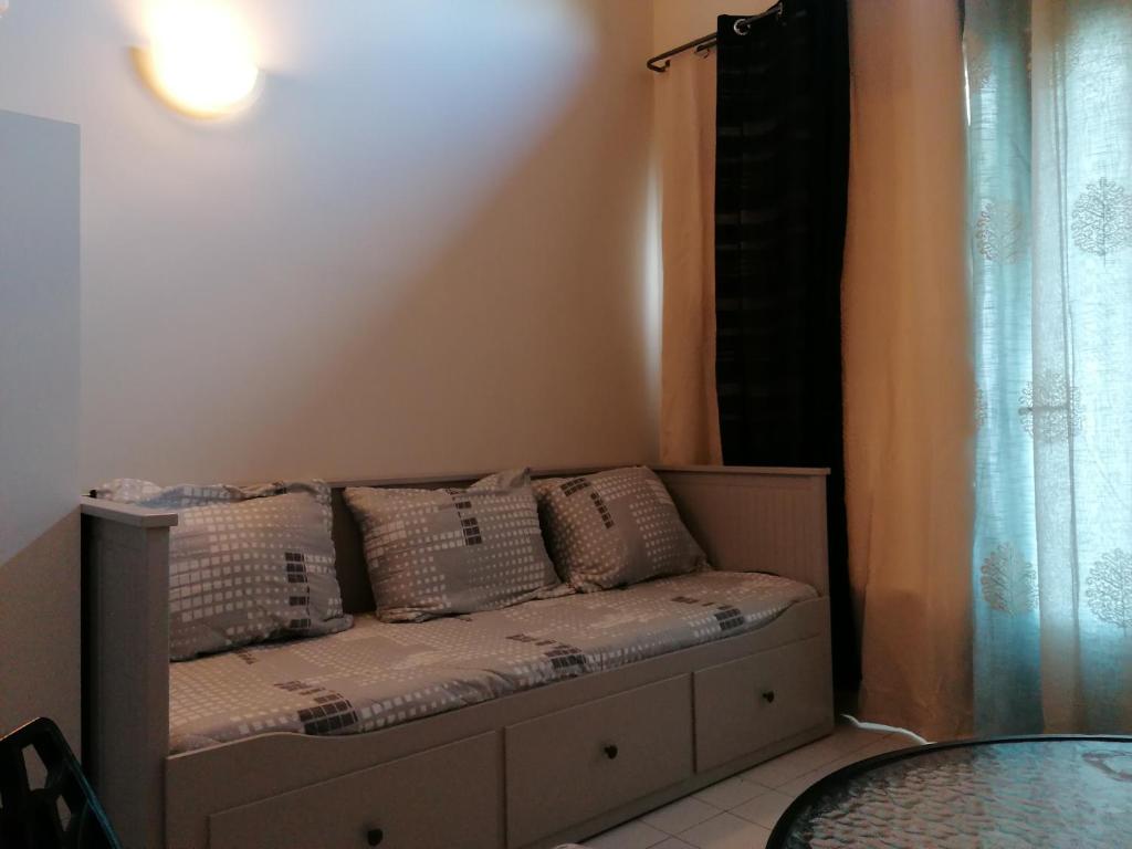 - un canapé avec des oreillers dans l'établissement Superbe studio proche de toutes commodités, à Franqueville-Saint-Pierre
