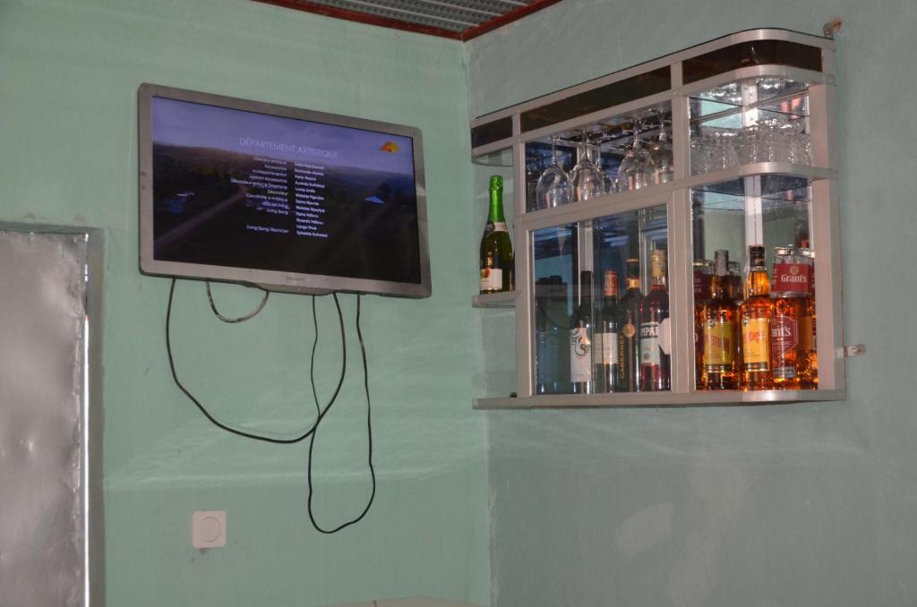 a television on a wall next to a bar at EDISON CITY PALACE GUEST HOME in Bertoua