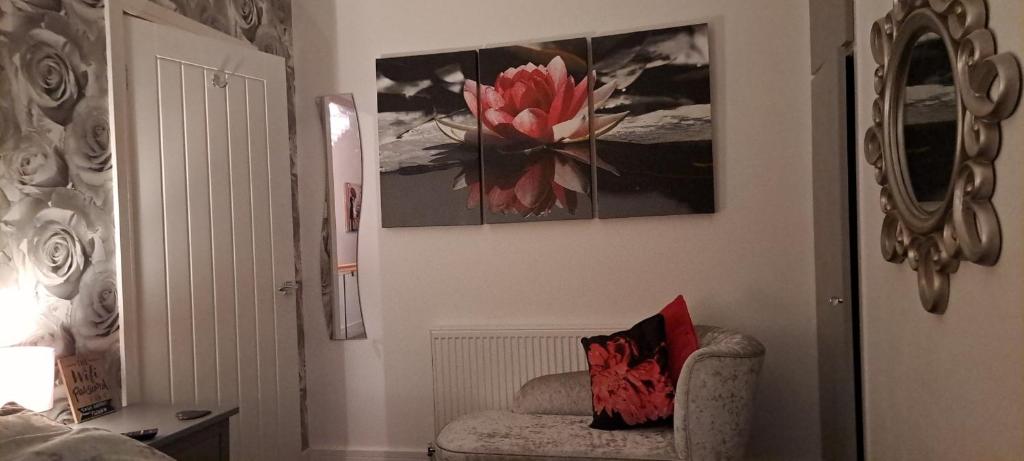 ein Wohnzimmer mit einem Stuhl und einem Gemälde an der Wand in der Unterkunft Cosy Double Room in Harrogate