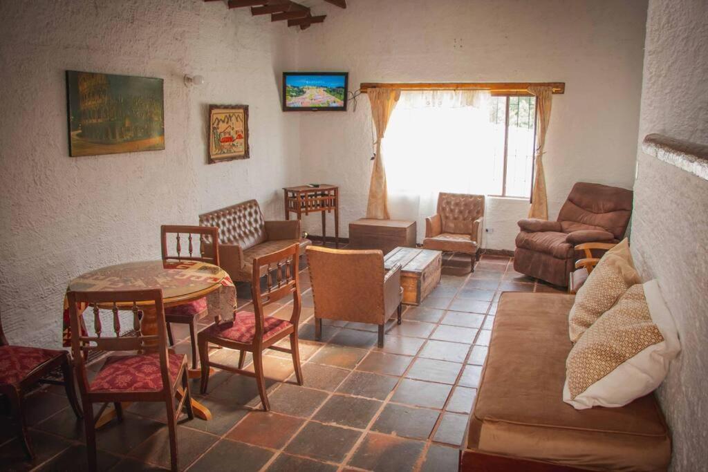 ein Wohnzimmer mit einem Sofa, einem Tisch und Stühlen in der Unterkunft Tierra Muisca en Guatavita in Guatavita