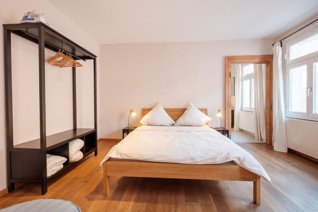 a bedroom with a large bed with white sheets at Zaunkönig Apartments in Baden-Baden