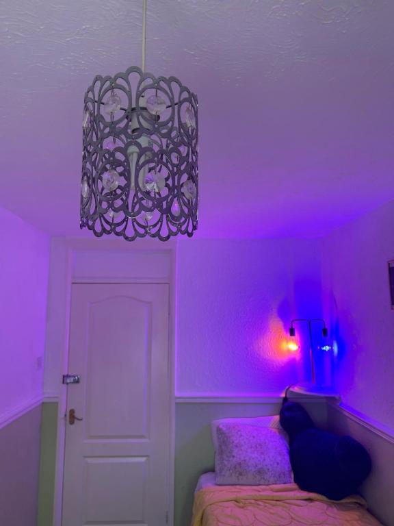 um quarto roxo com uma cama e um lustre em LN host em Rockingham