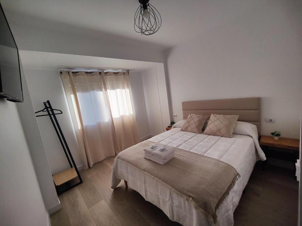 Un dormitorio con una cama grande con sábanas blancas. en O Lar da Muralla, en Lugo