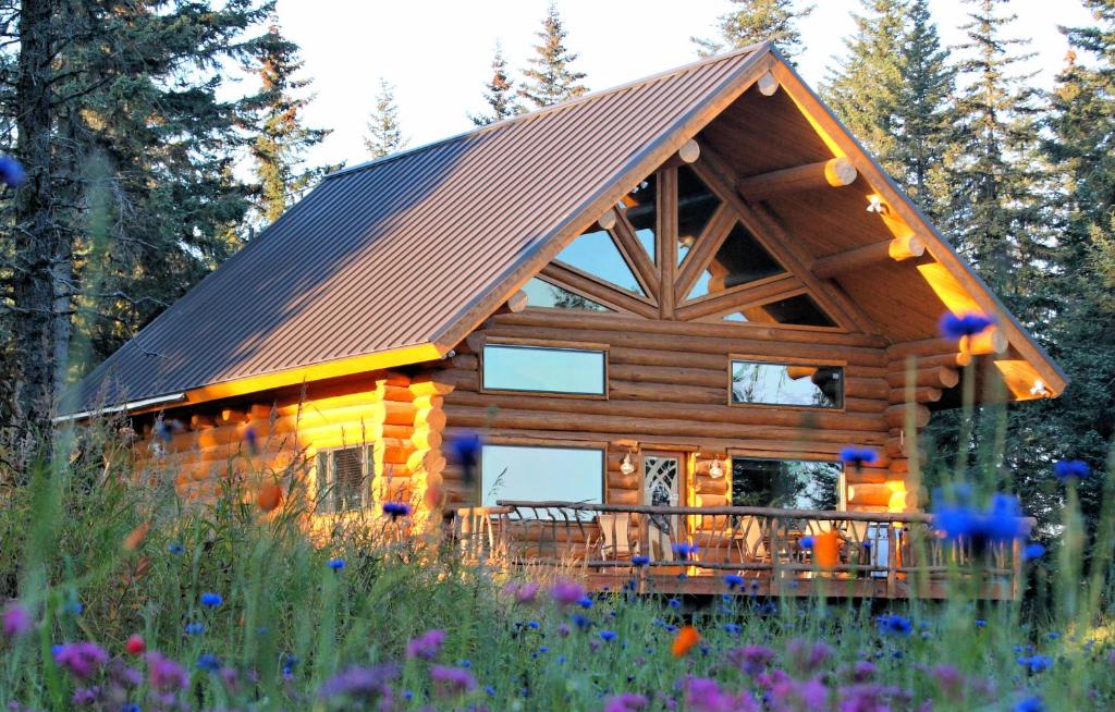 a log cabin with a balcony in the woods at Anchor Point Captain Cook Lodge in Anchor Point