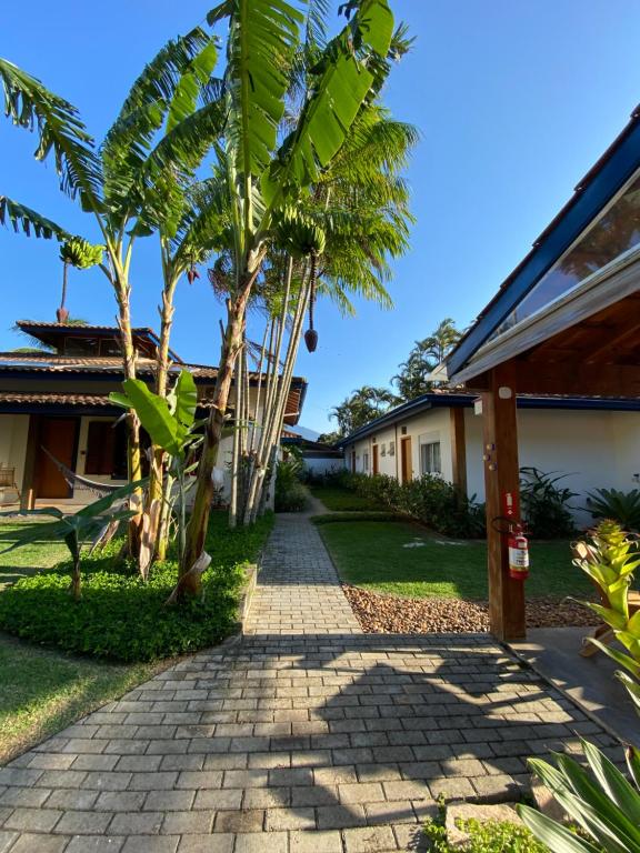 a walkway leading to a house with palm trees at Ao Mar - Hospedagem in São Sebastião