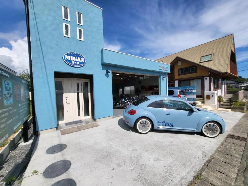 Niebieski samochód zaparkowany przed budynkiem w obiekcie Seaside Garage Shima - Vacation STAY 77073v w mieście Shima