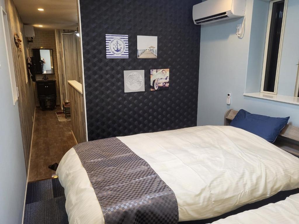 a bedroom with a bed and a wall with pictures at Seaside Garage Shima - Vacation STAY 85775v in Shima