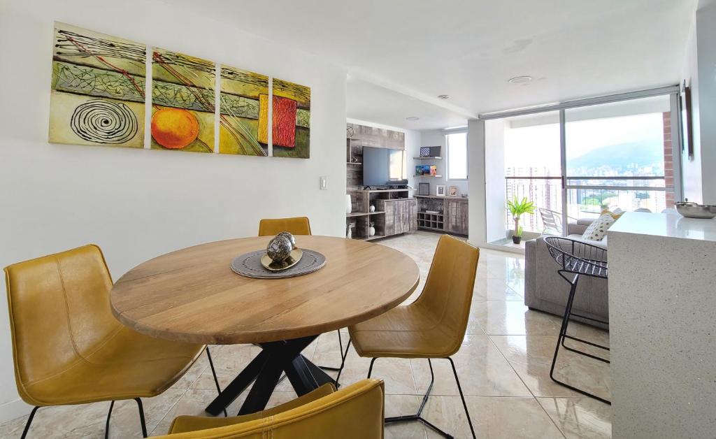 cocina y comedor con mesa y sillas en Modern High-Rise 2/2 Apartment with City View., en Sabaneta