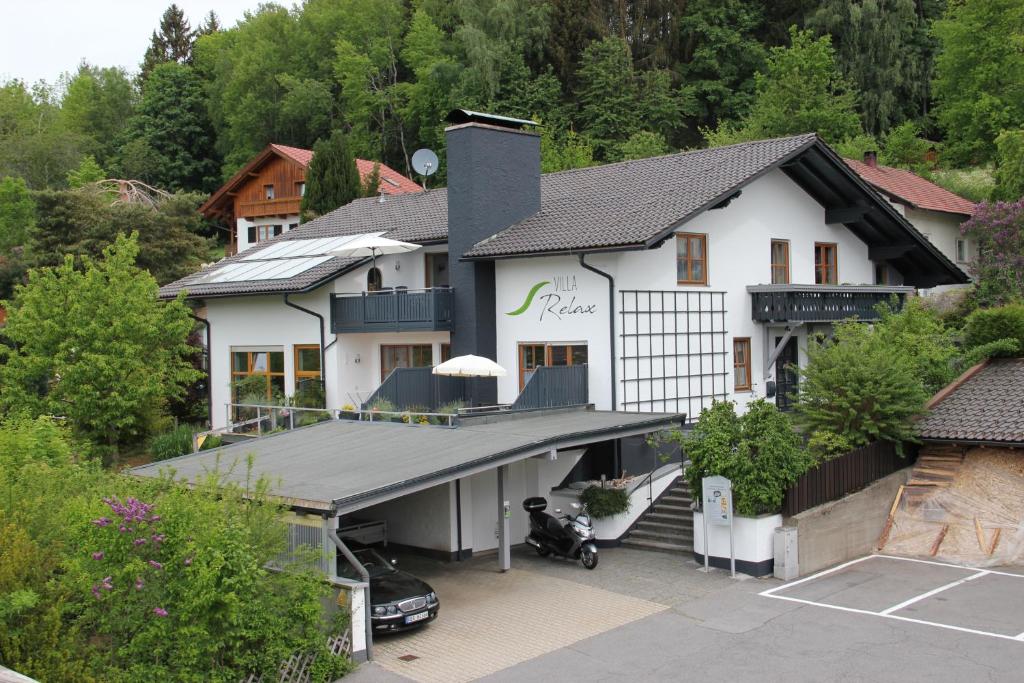 eine Luftansicht eines Hauses mit Parkplatz in der Unterkunft Villa Relax - Ferienwohnungen & Hallenbad & Relaxgarten in Bodenmais