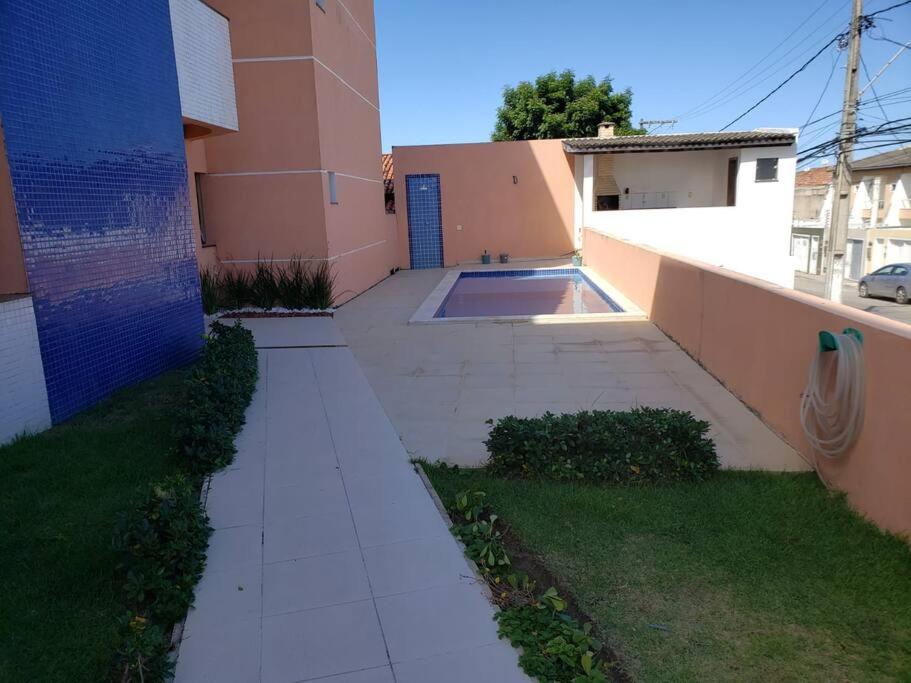 una acera que conduce a una casa con piscina en Relaxe e curta num duplex completíssimo, en Lauro de Freitas