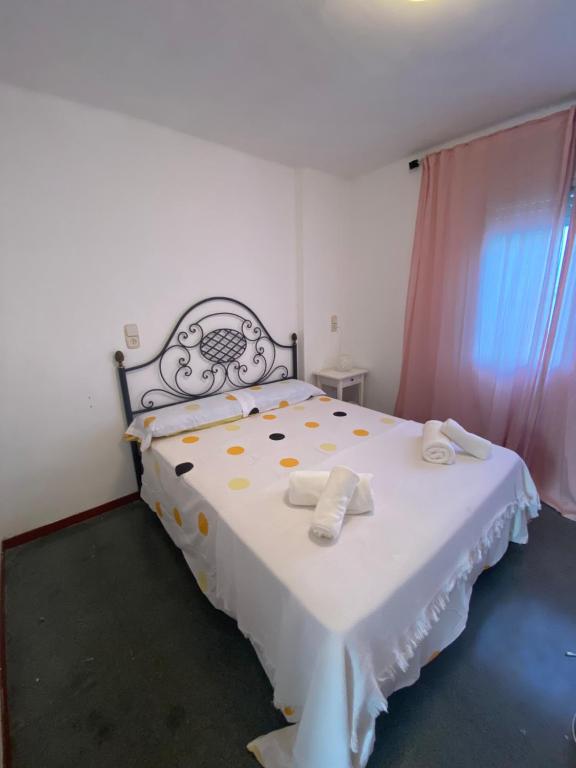 een slaapkamer met een wit bed en handdoeken bij Apartamento en L Ampolla in L'Ampolla