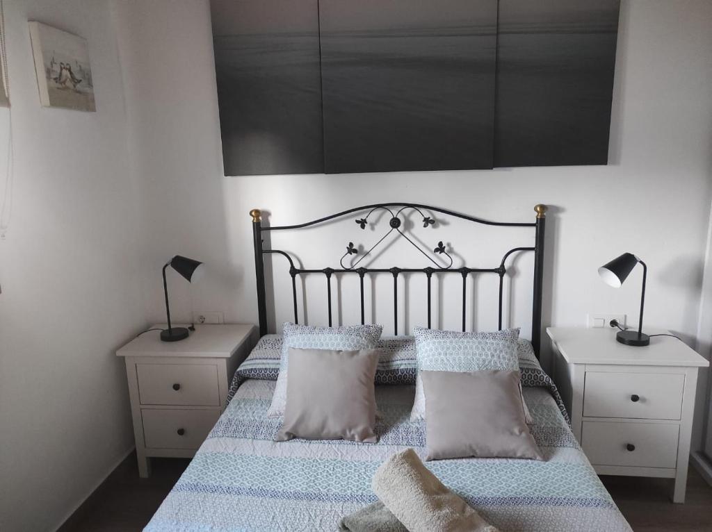 sypialnia z łóżkiem z 2 stolikami nocnymi i 2 lampami w obiekcie Chalet cerca de la playa La Barrosa w mieście Chiclana de la Frontera