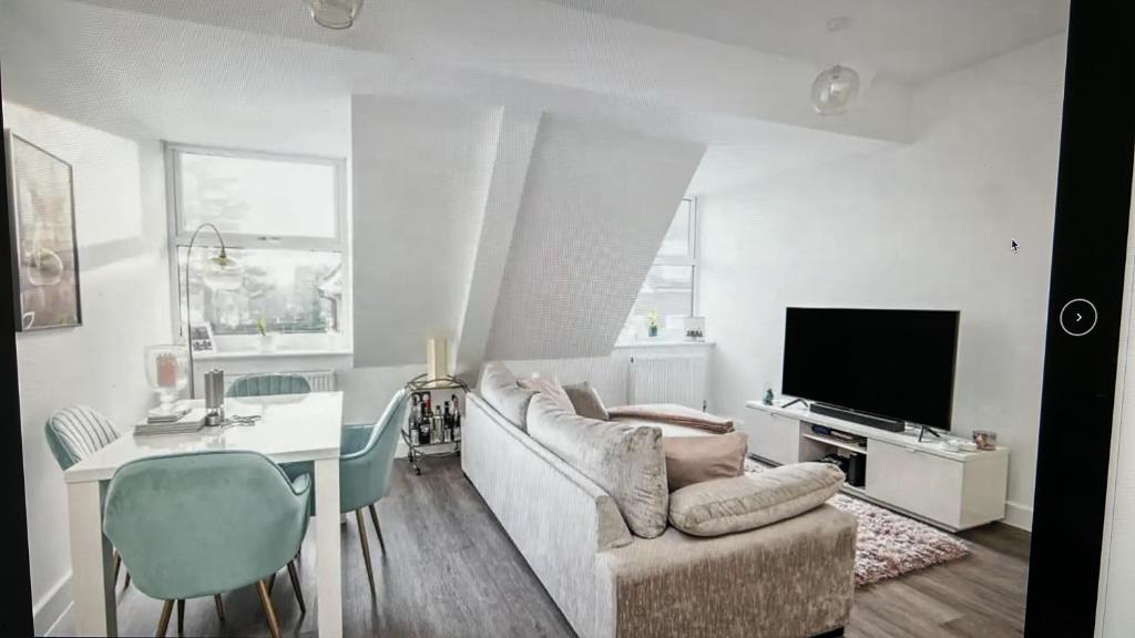 sala de estar con sofá, mesa y TV en Solihull Town Centre Spacious Studio Apartment en Solihull