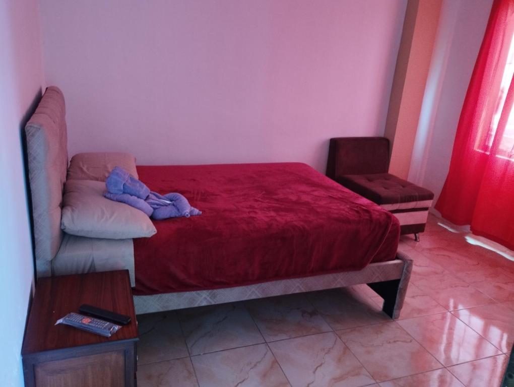 a bedroom with a bed and a couch with a stuffed animal on it at Kiara's house in Puerto Baquerizo Moreno