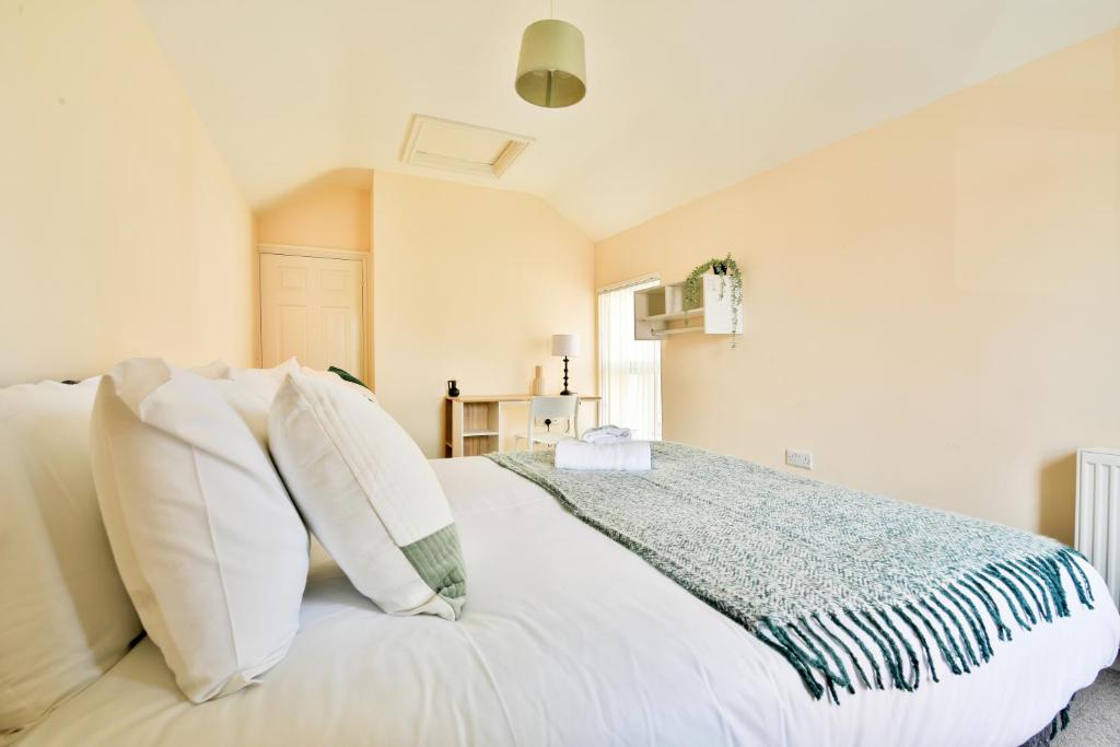 a bedroom with a white bed with white pillows at StayRight 3-Bed Home Near Central Cardiff- Sleeps 8, Twin Or King Beds in Cardiff