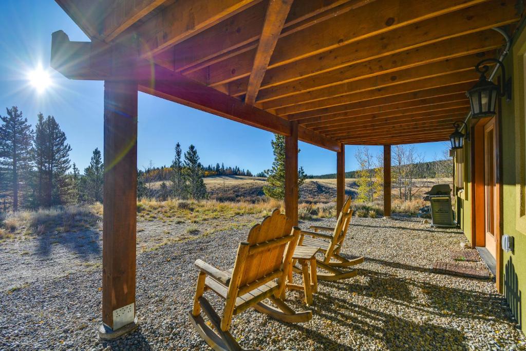 2 chaises en bois assises sur une terrasse couverte d'une maison dans l'établissement Cozy Alma Mountain Retreat Fireplace and Grill, à Alma