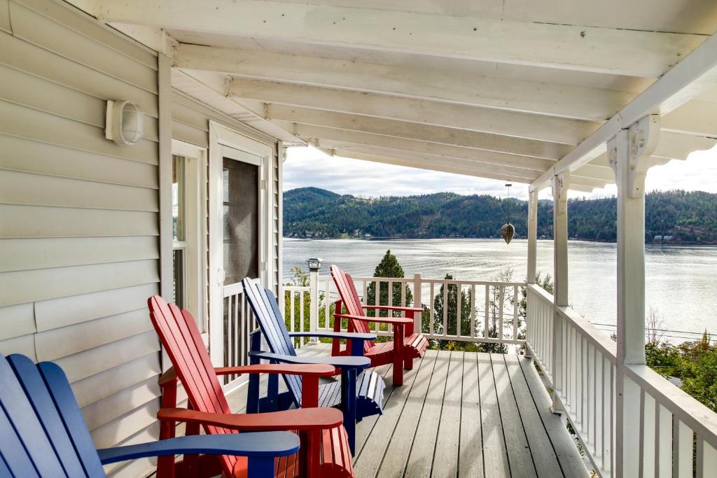 a porch with red and blue chairs on a house at Harrison Getaway with Deck and Lake Views! in Harrison