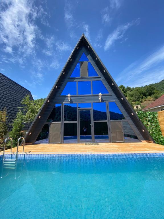 a triangle shaped house with a swimming pool at Lerik House in Lerik