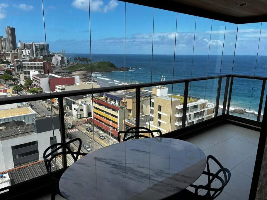 a table on a balcony with a view of the ocean at Salvador farol da barra 01 Apartamento Vista Mar in Salvador