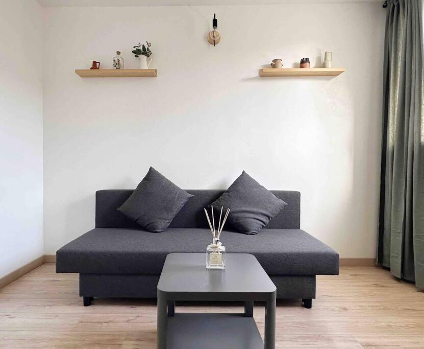 un salon avec un canapé bleu et une table dans l'établissement ULTimade Apartment T3 proche Paris/Tramway & Métro, à Ivry-sur-Seine