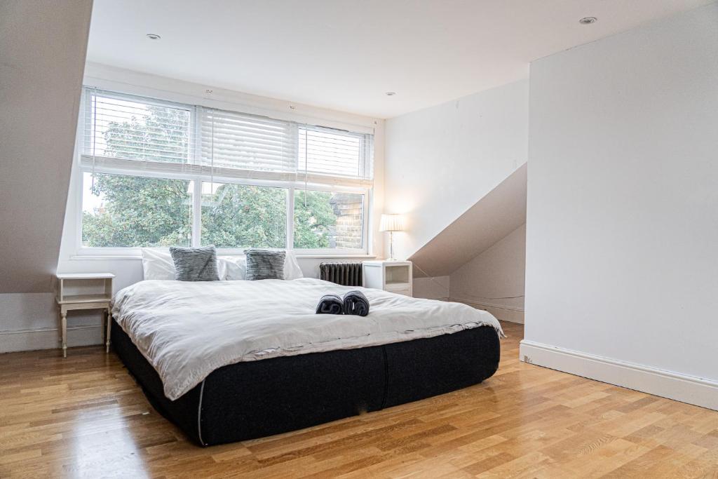 a bedroom with a large bed and a large window at Hackney Central Houseshare in London