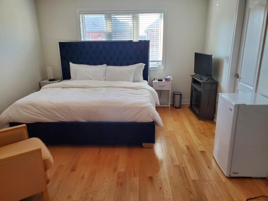 RAESABU GUEST HOUSE في برامبتون: غرفة نوم مع سرير كبير مع اللوح الأمامي الأزرق
